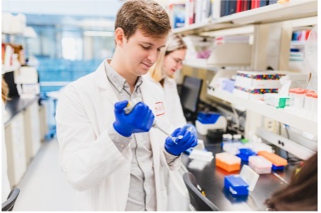 Erblin Cani pipetting in a lab